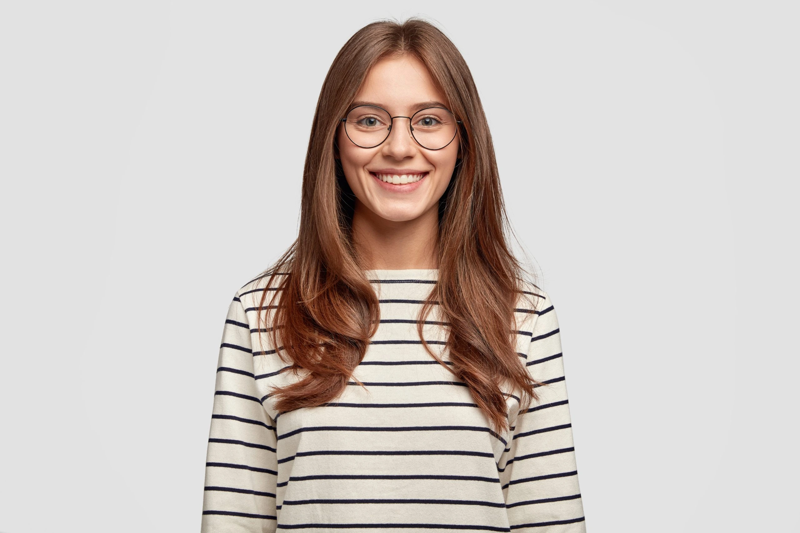 Smiling young woman with glasses portrait on gray background